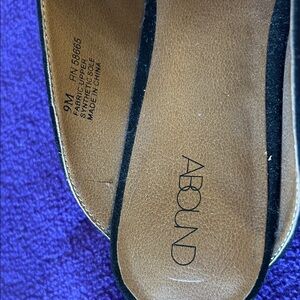 Black suede mules with big bow on top.